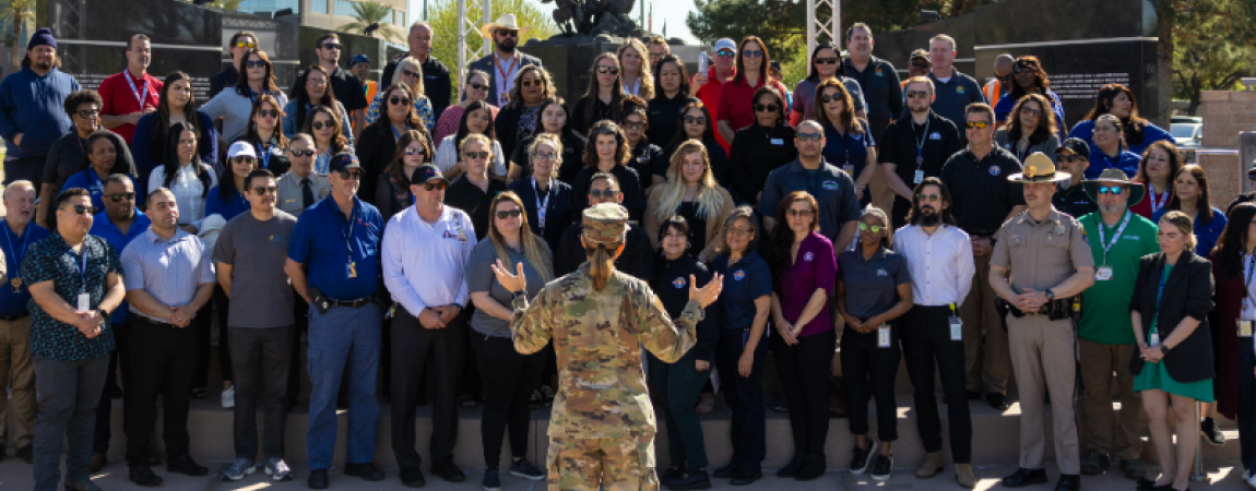 Person in fatigues talks to a crowd of agency recruiters