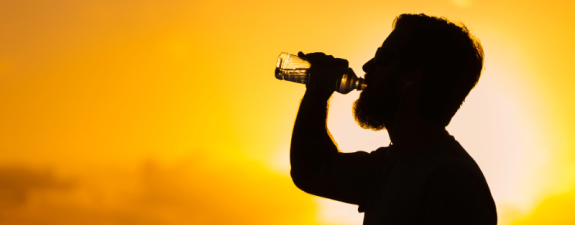 ADOA News Release label and a silhouette of a man drinking water with an intense sun behind him