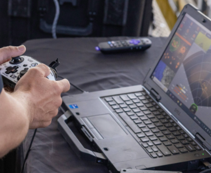 ADOA News Release graphic and a person with a video game remote watching radar on a laptop