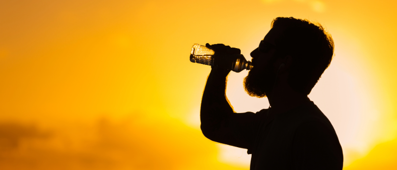 ADOA News Release label and a silhouette of a man drinking water with an intense sun behind him